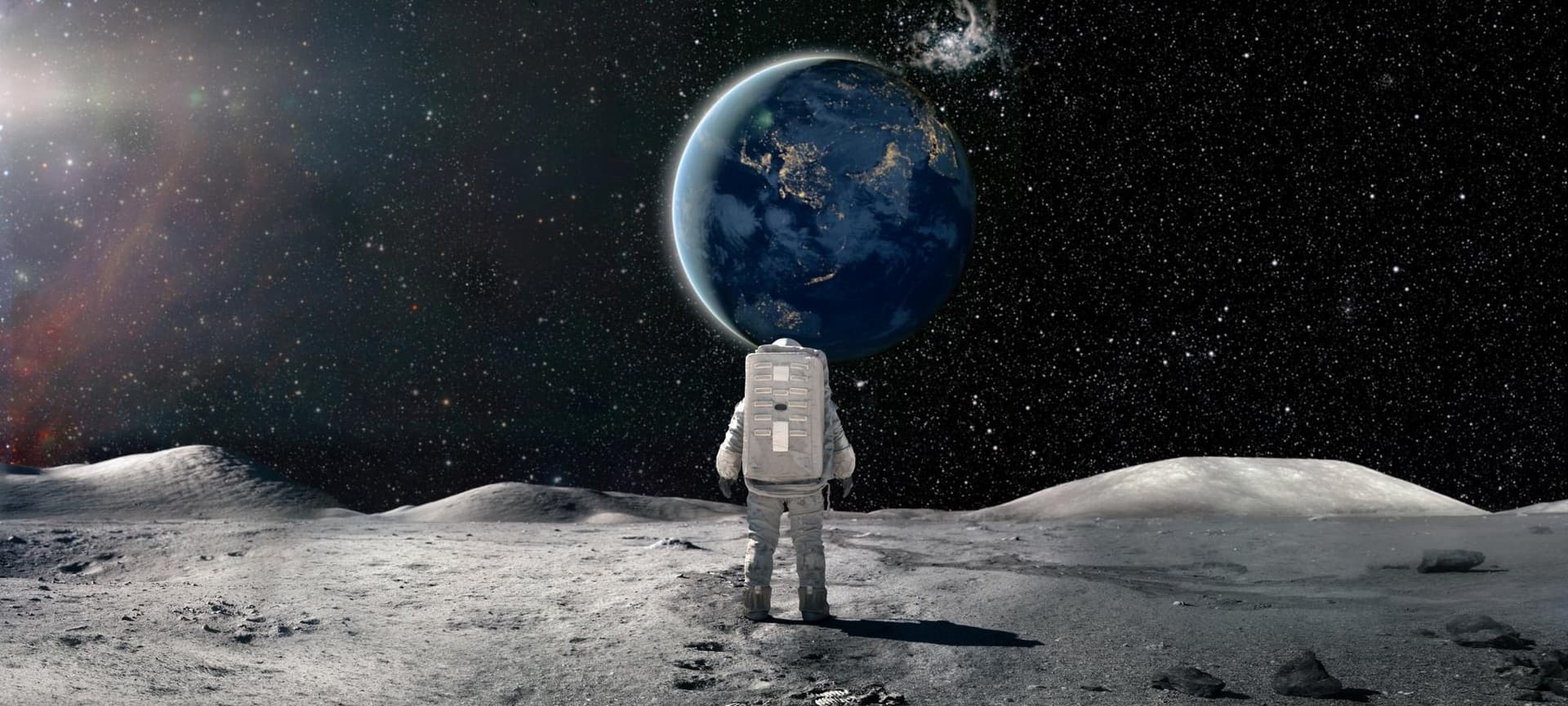 An astronaut standing on the moon and looking at Earth from a distance