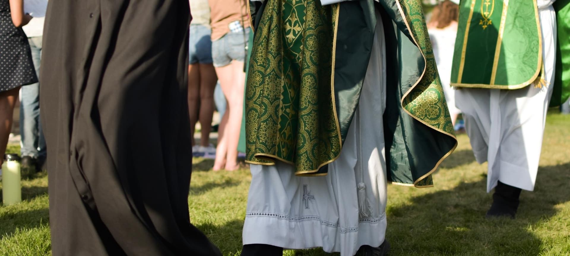 Three clergy dressed in clerical garb walking