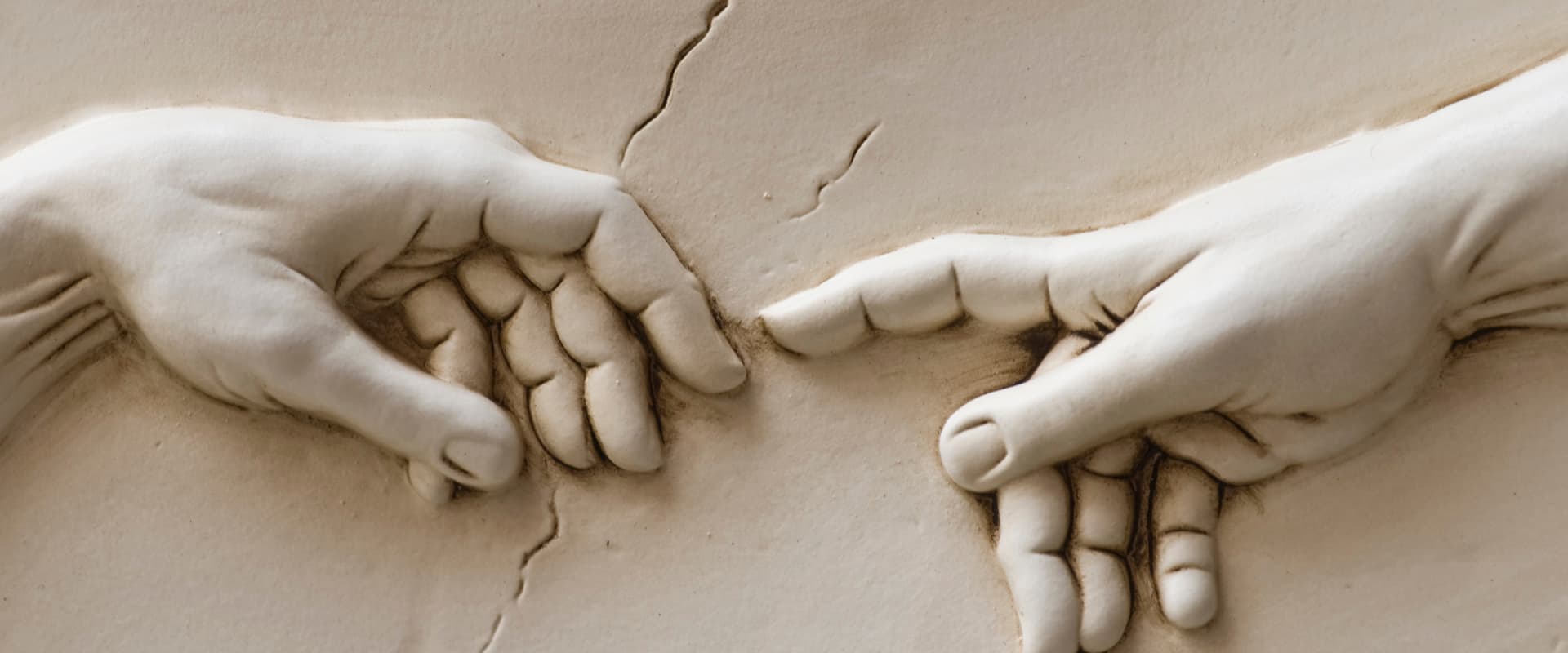 Hand of God reaching out to Adam in sculpture
