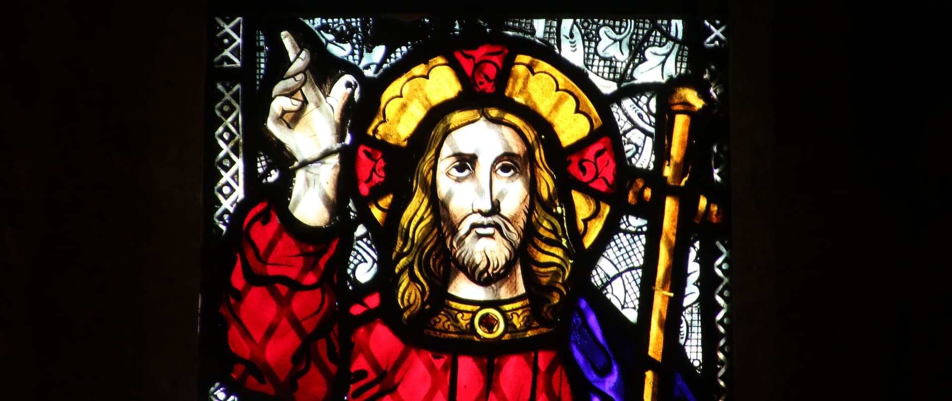 jesus pointing toward the sky on stained glass window
