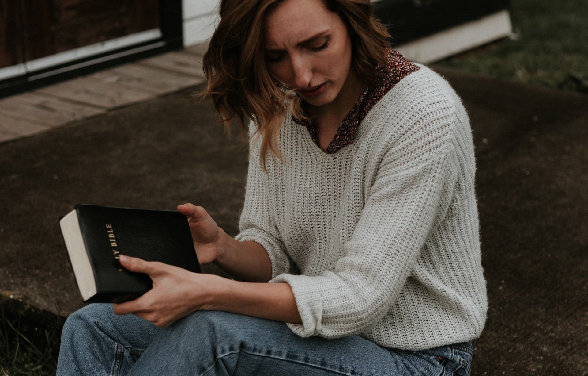 woman sitting with bible in sweater