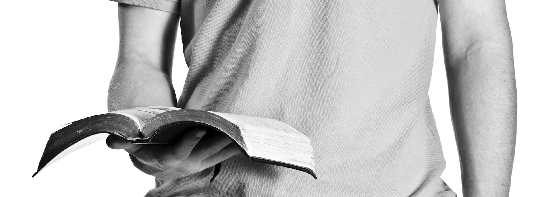 man standing holding a bible in right hand
