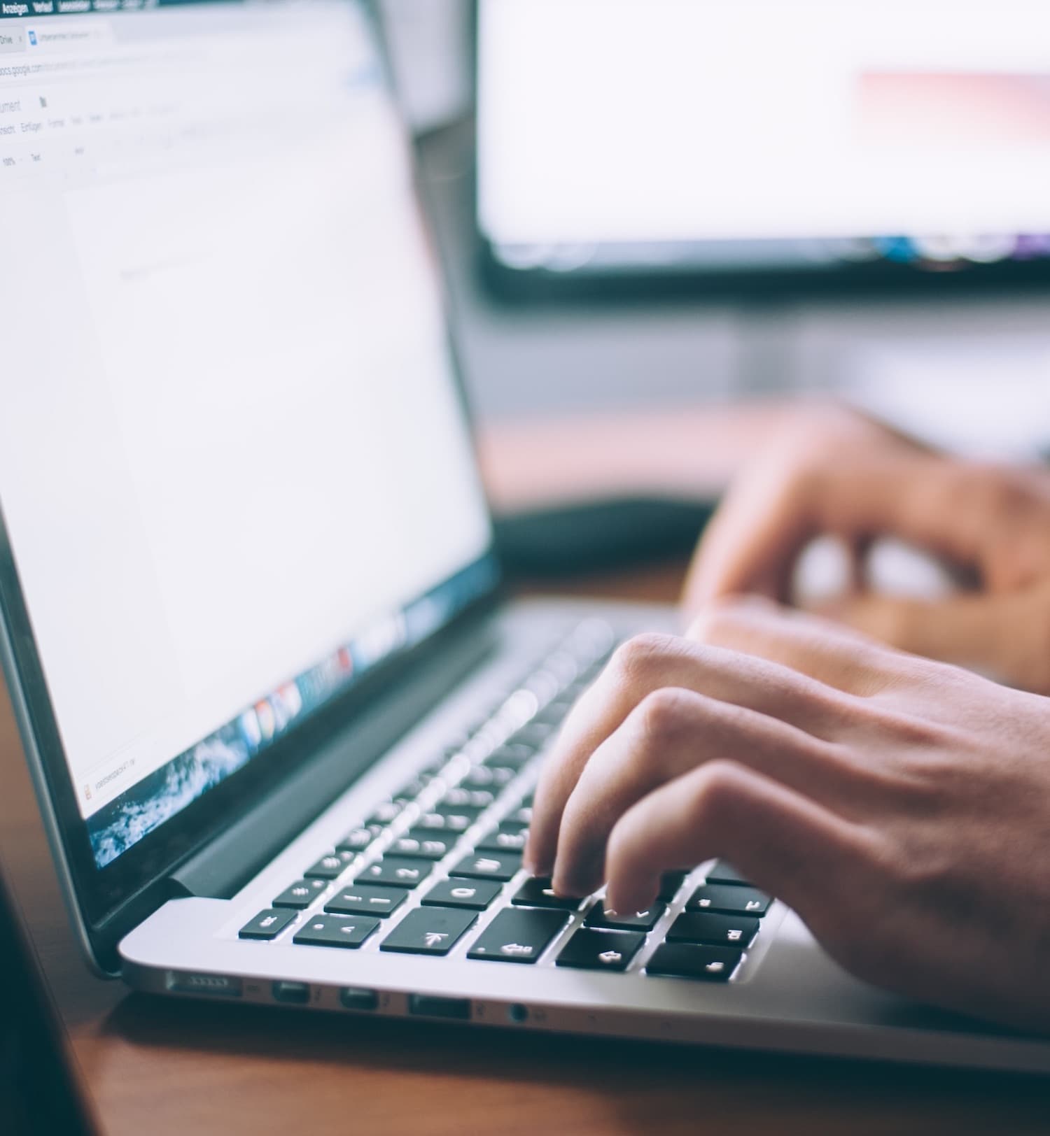 hands typing on a laptop