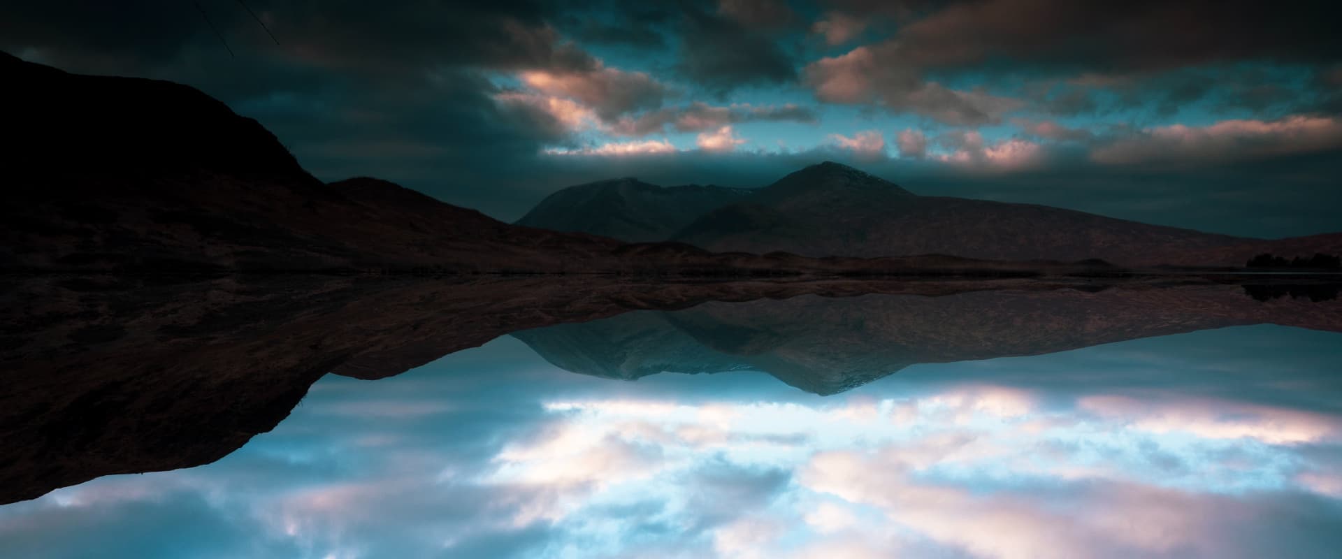 reflection of sky on lake with mountains behind
