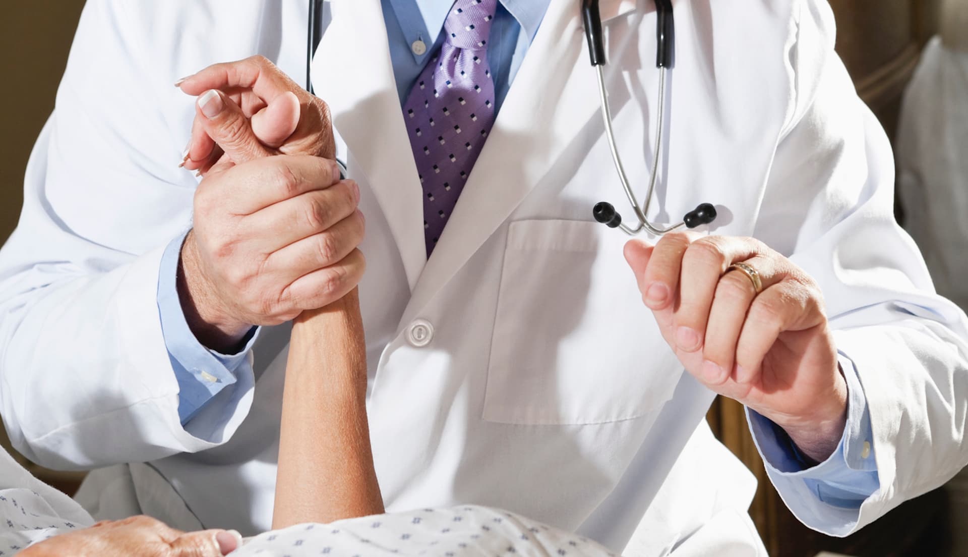 a doctor holding the hand of a patient