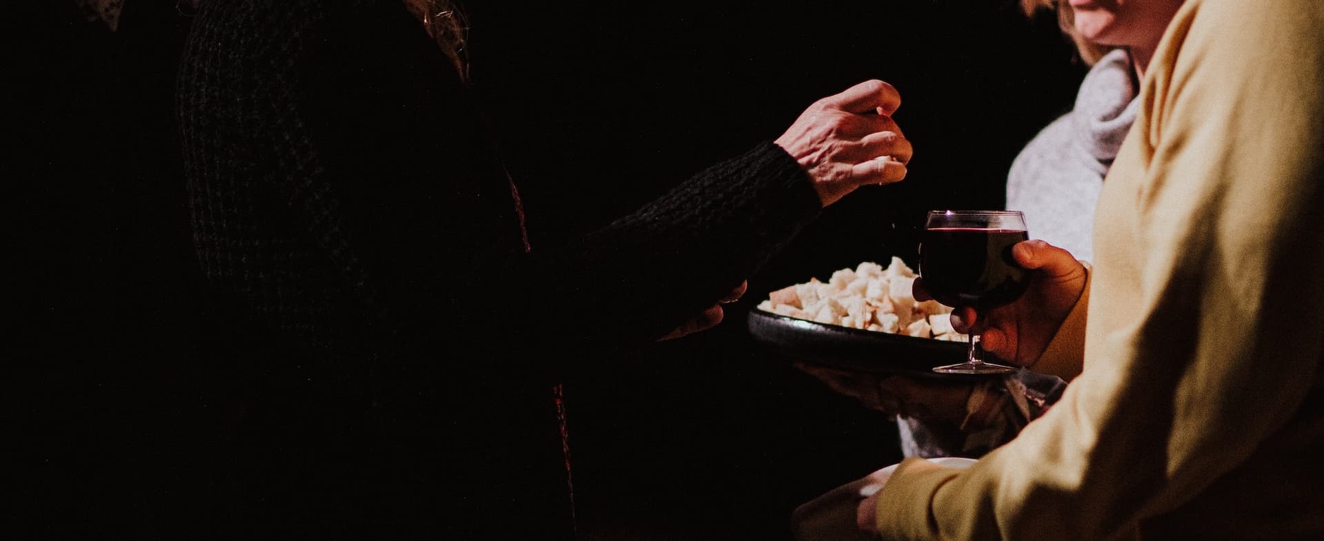 person taking communion from two servers