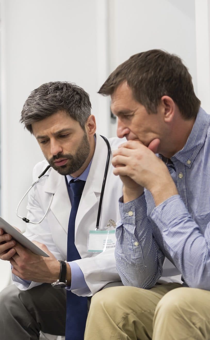 man and his doctor looking at iPad