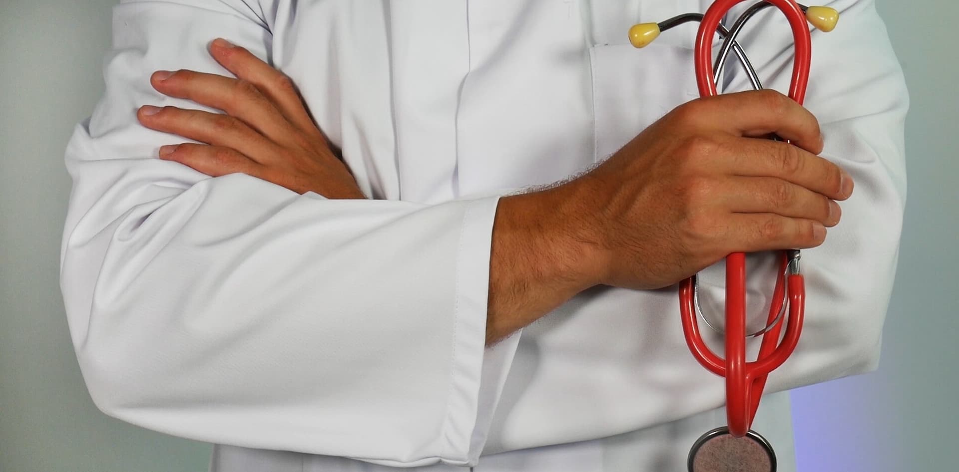 doctor holding stethoscope with arms crossed