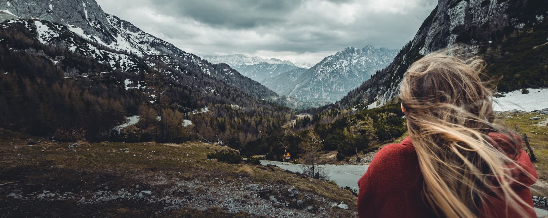 woman facing away from the camera toward mountain range