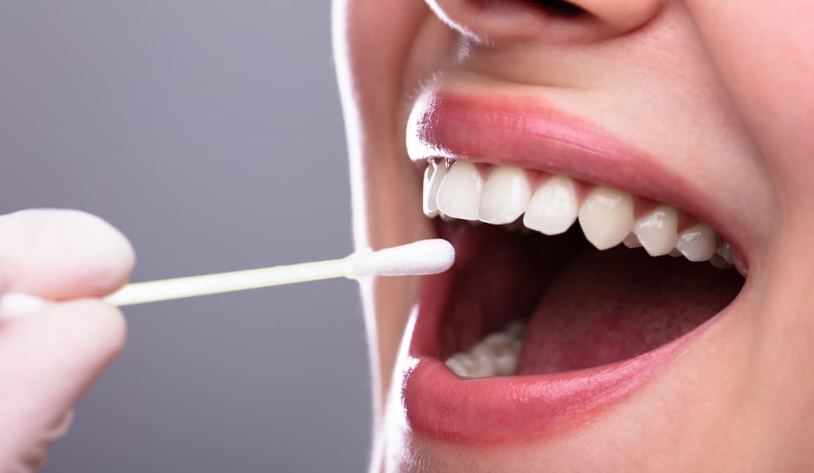 a mouth with a cotton swab entering it