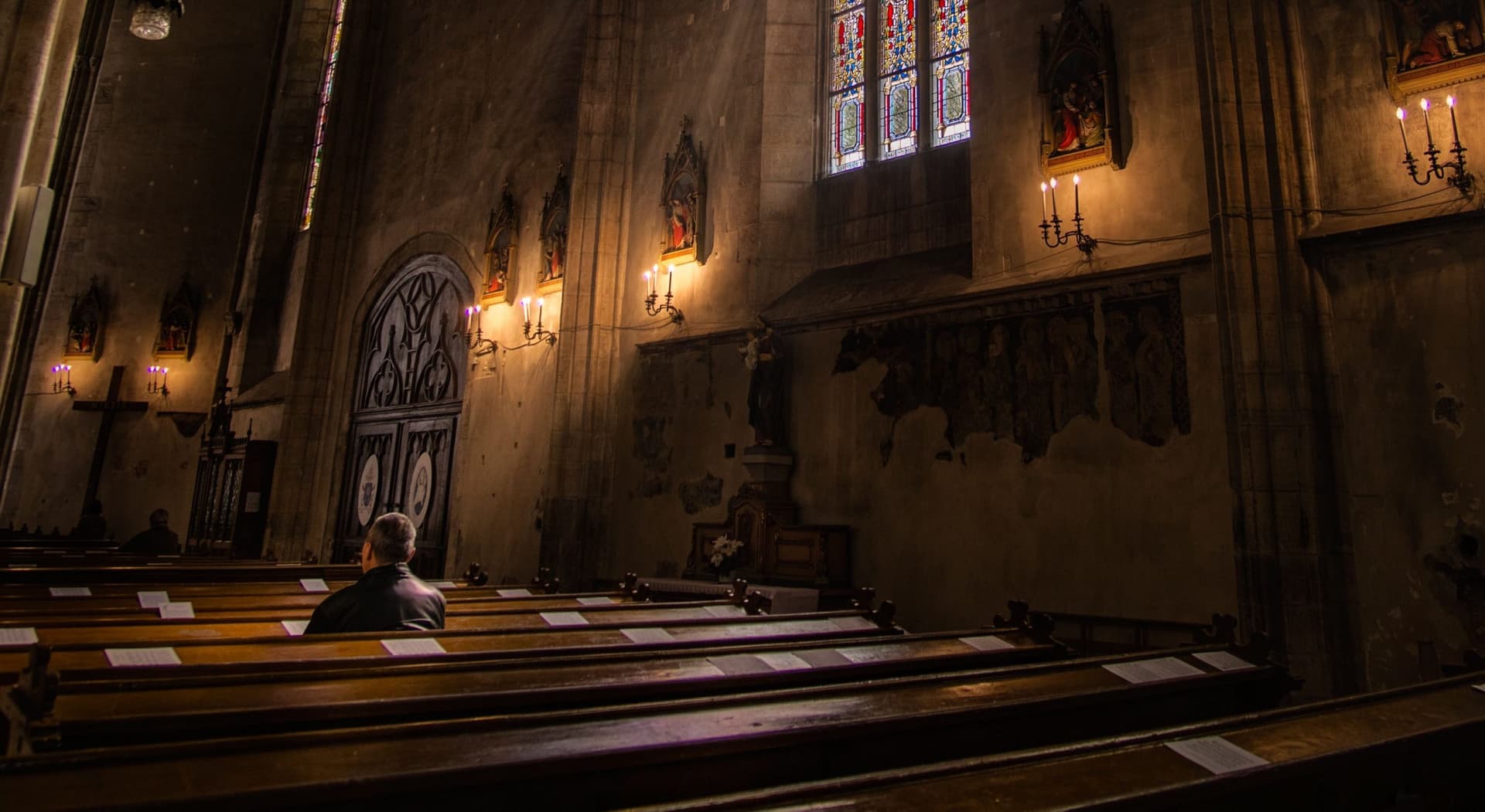man sitting alone in an empty church