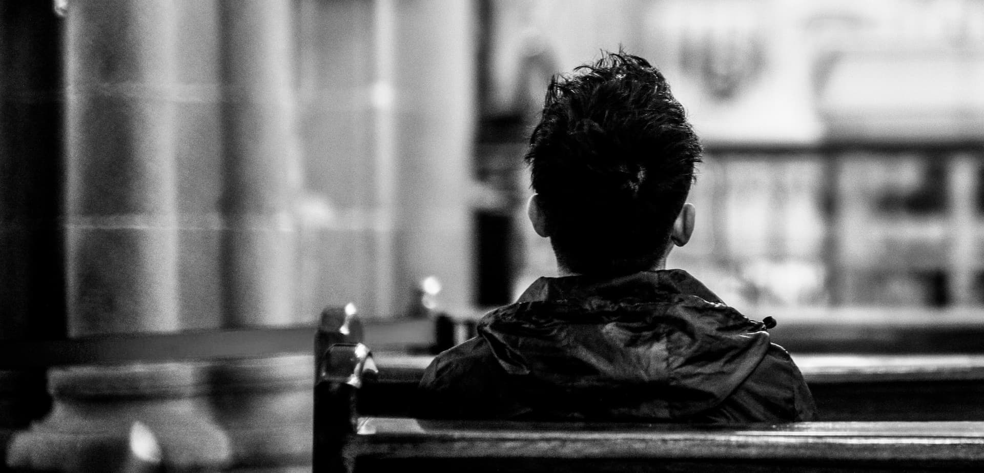 person sitting alone in a church pew