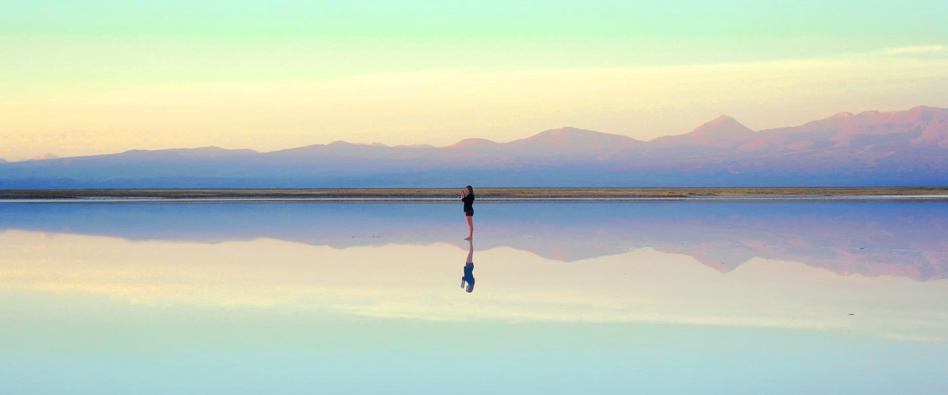 woman standing near a body of water reflection