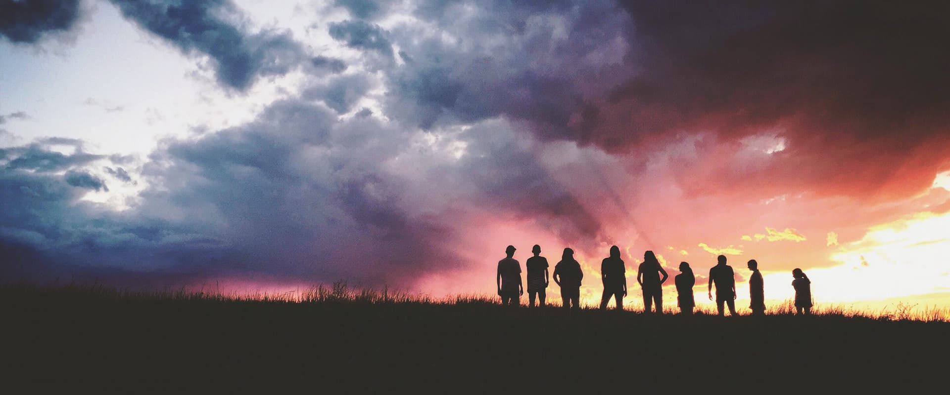 sillhouettes on a hill against a sunset