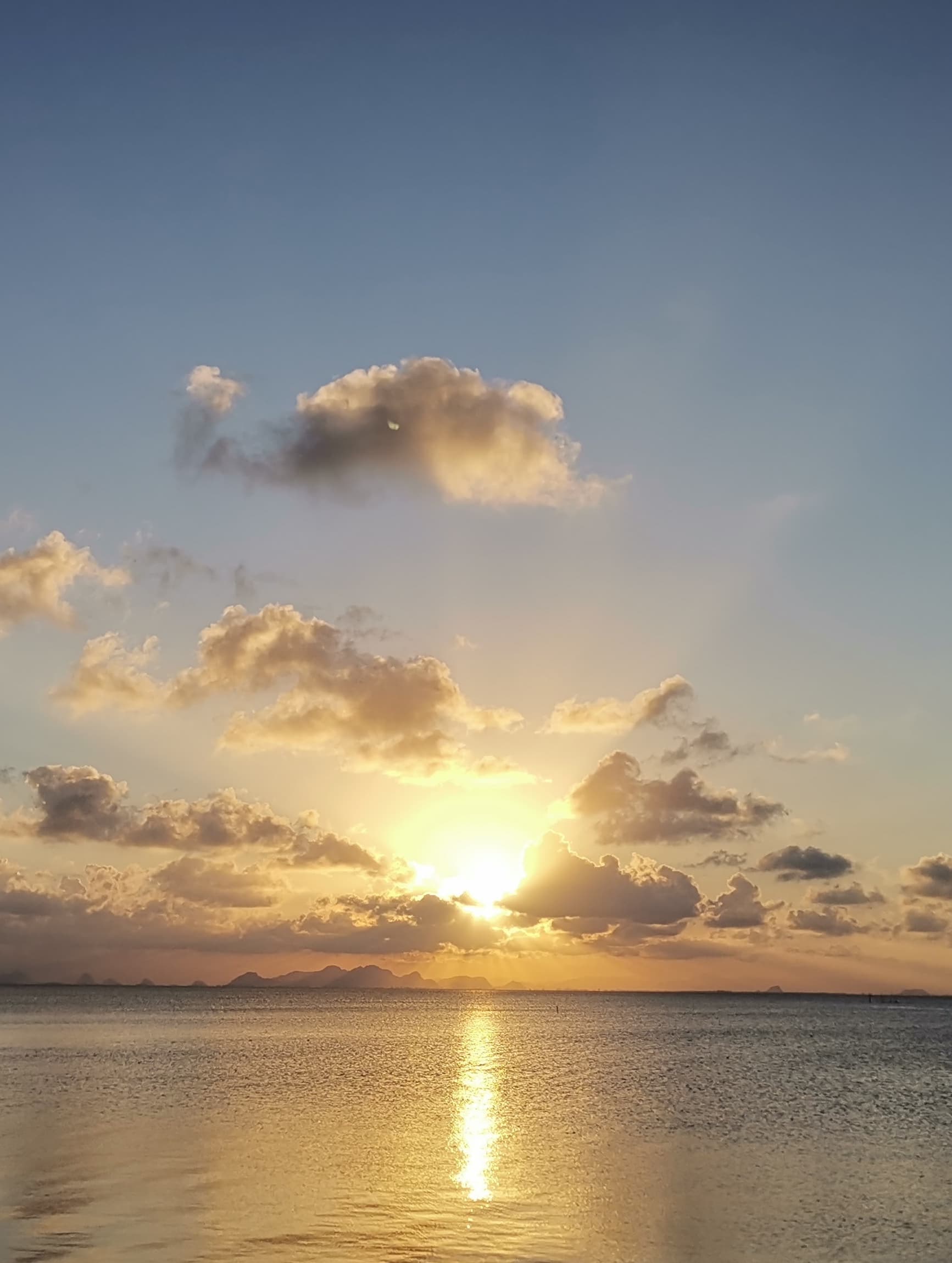 sun peeking through clouds over the ocean