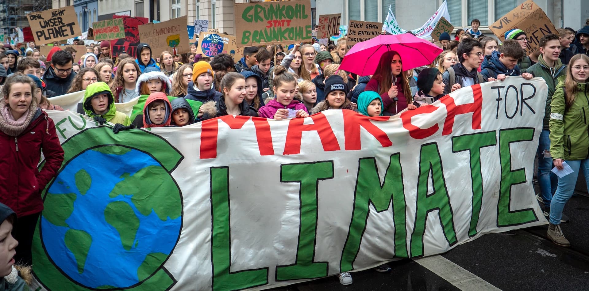 Climate March participants hold a large banner that says March for Climate