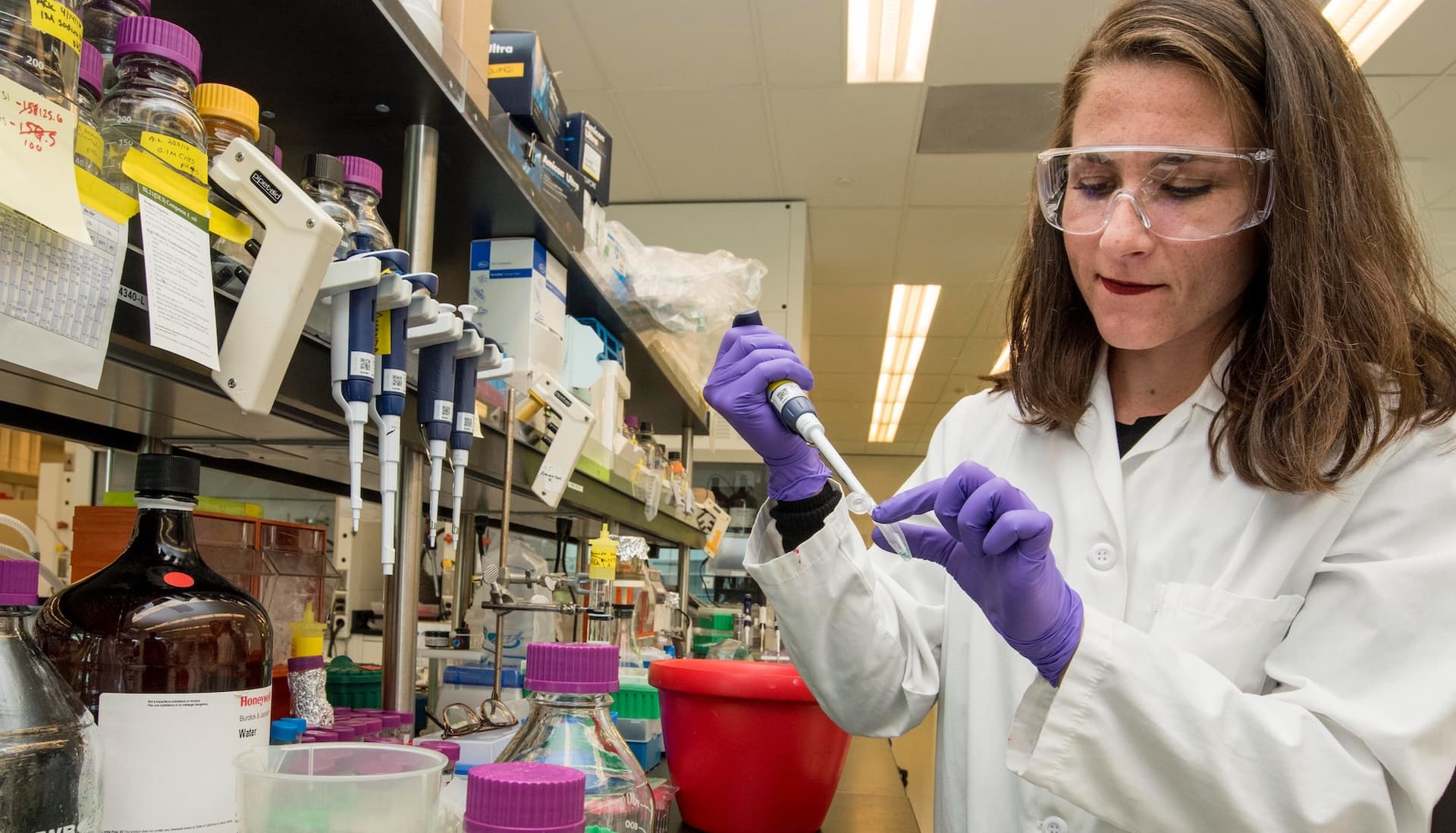 a woman scientist pipettes in a lab
