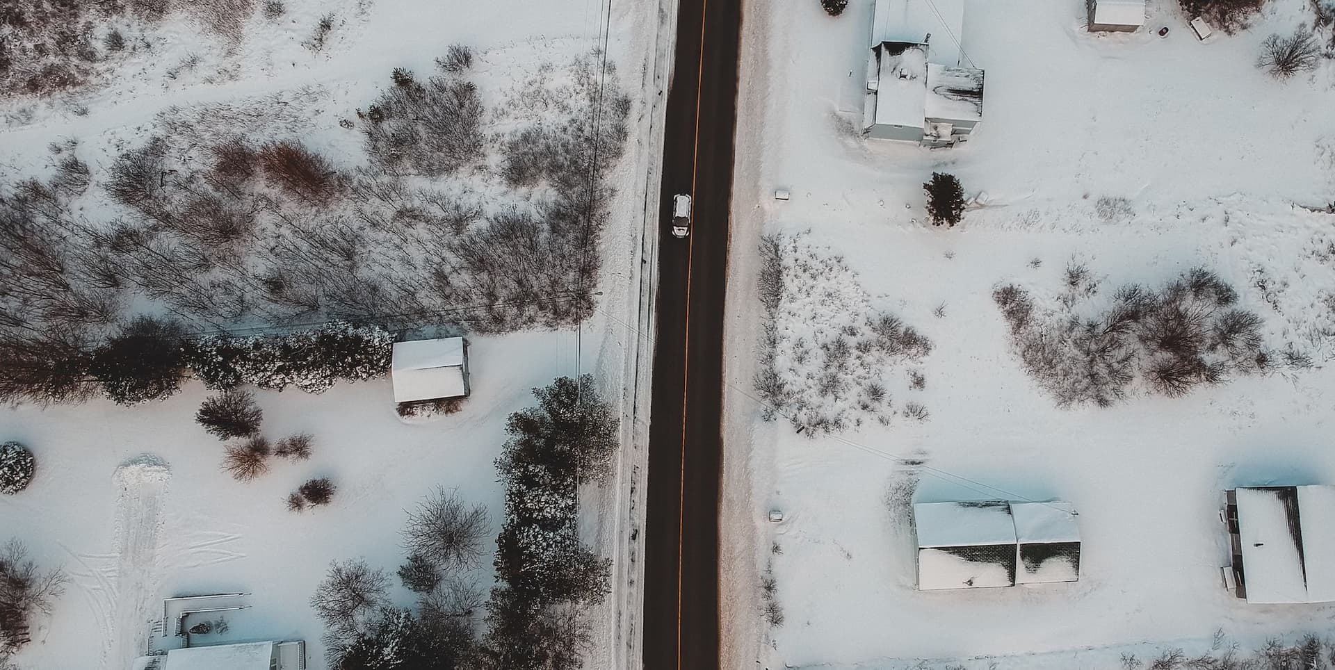 a car driving in a snowy neighborhood