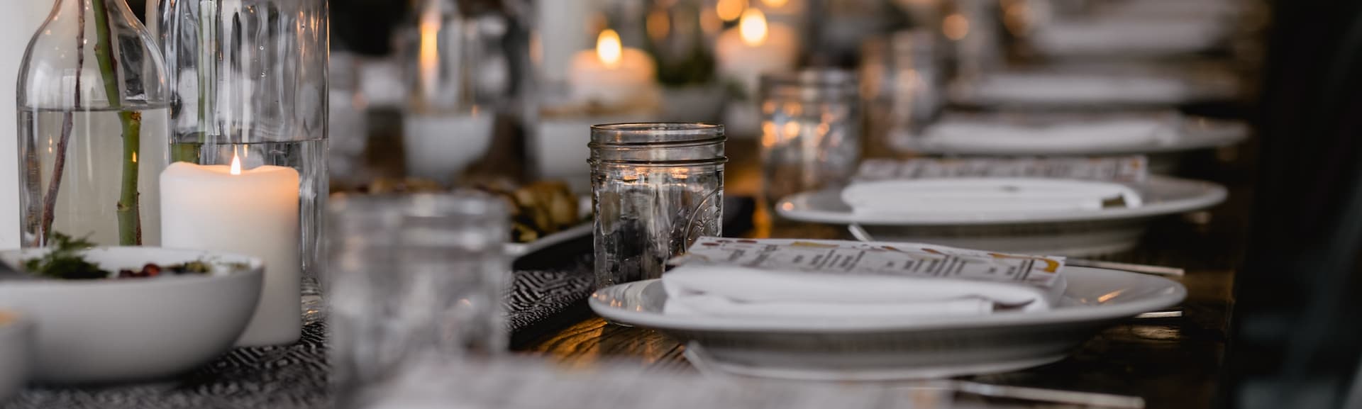 long table full of table settings and candles