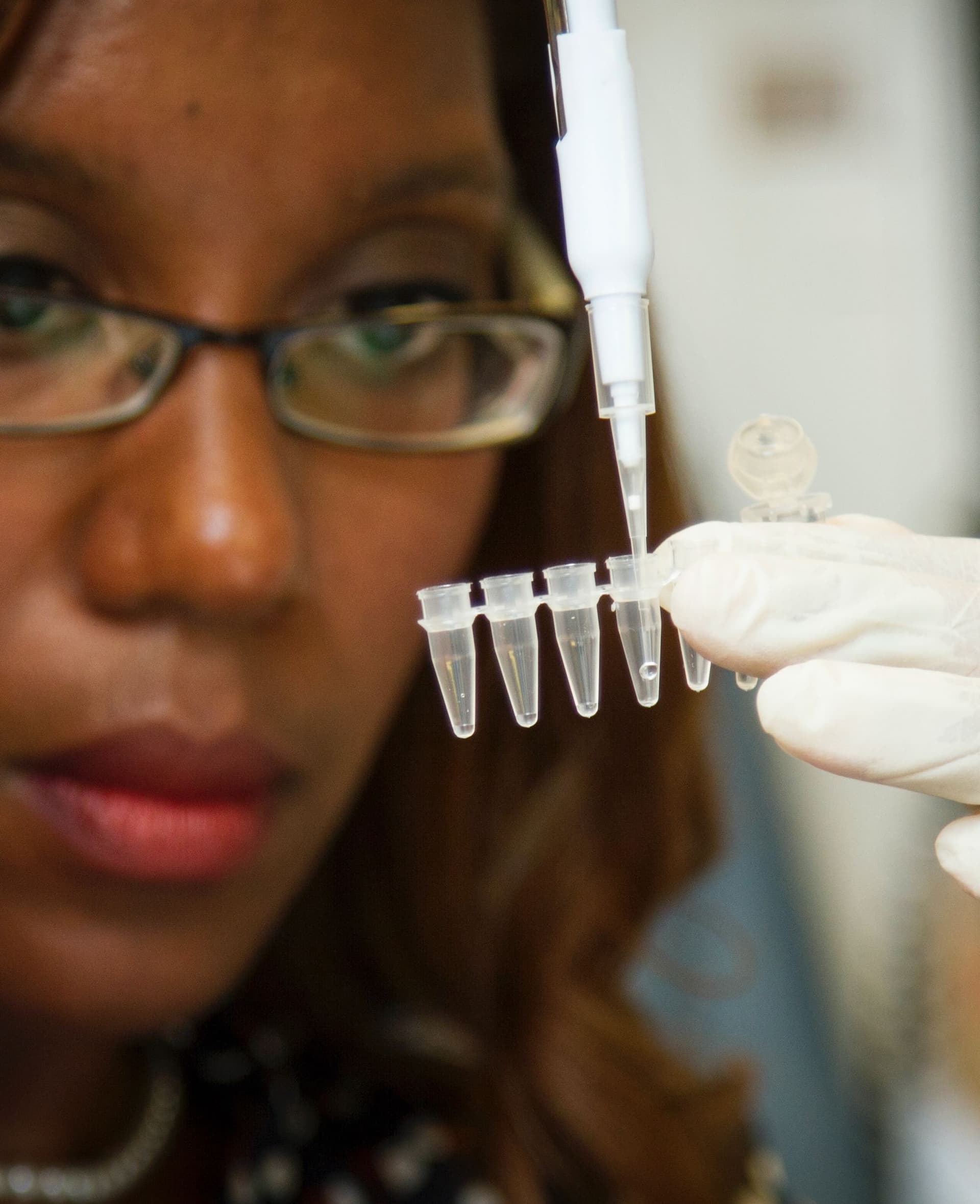 woman pipetting into plastic containers