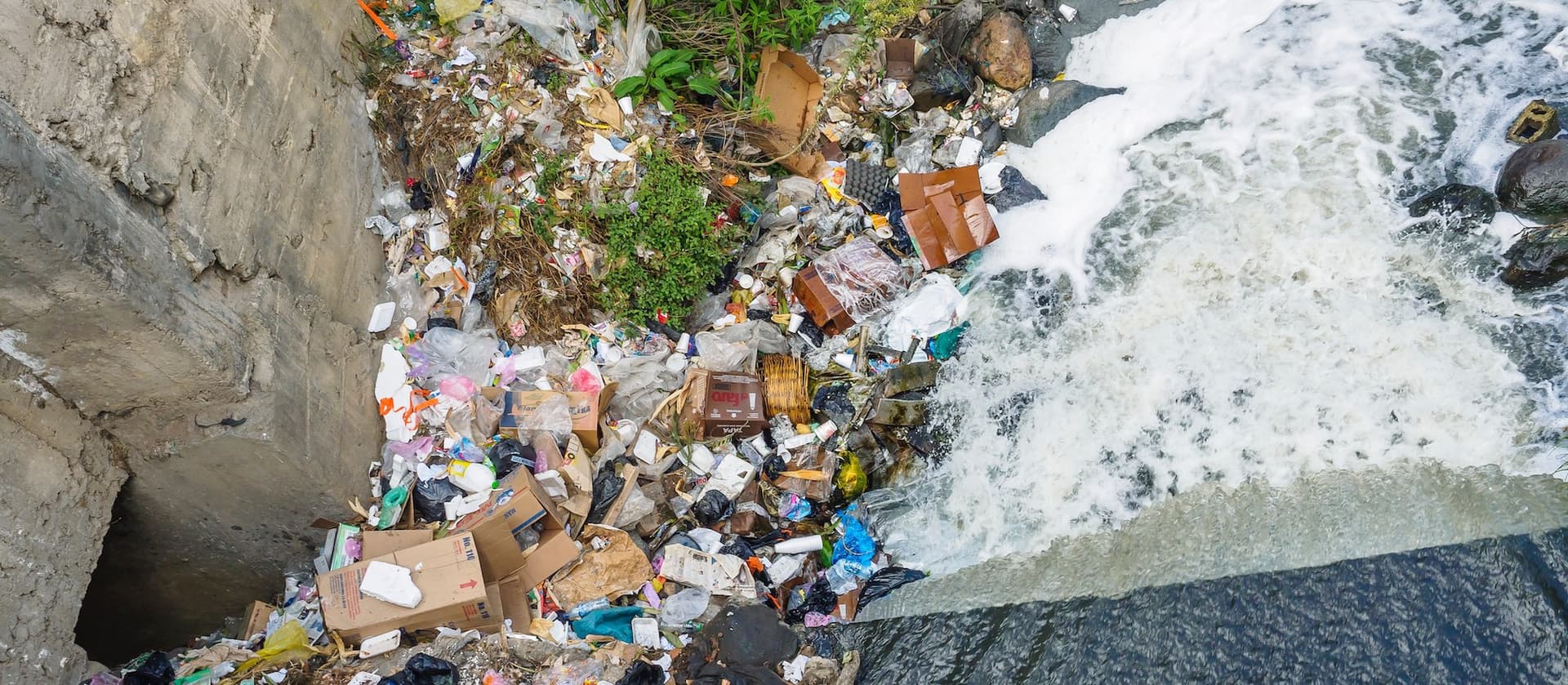 trash piling up next to a water dam