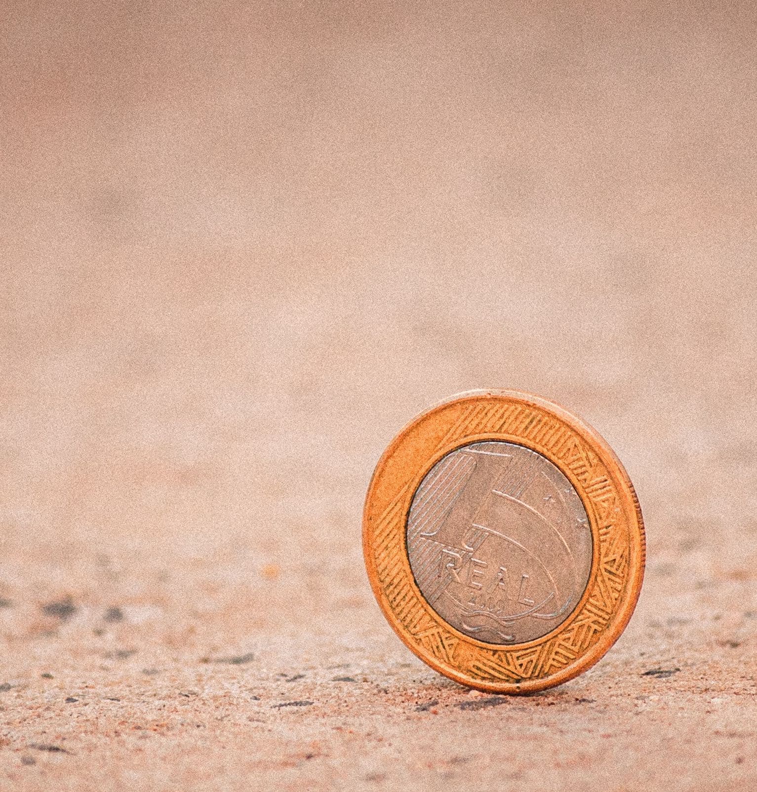 coin standing upright on pavement