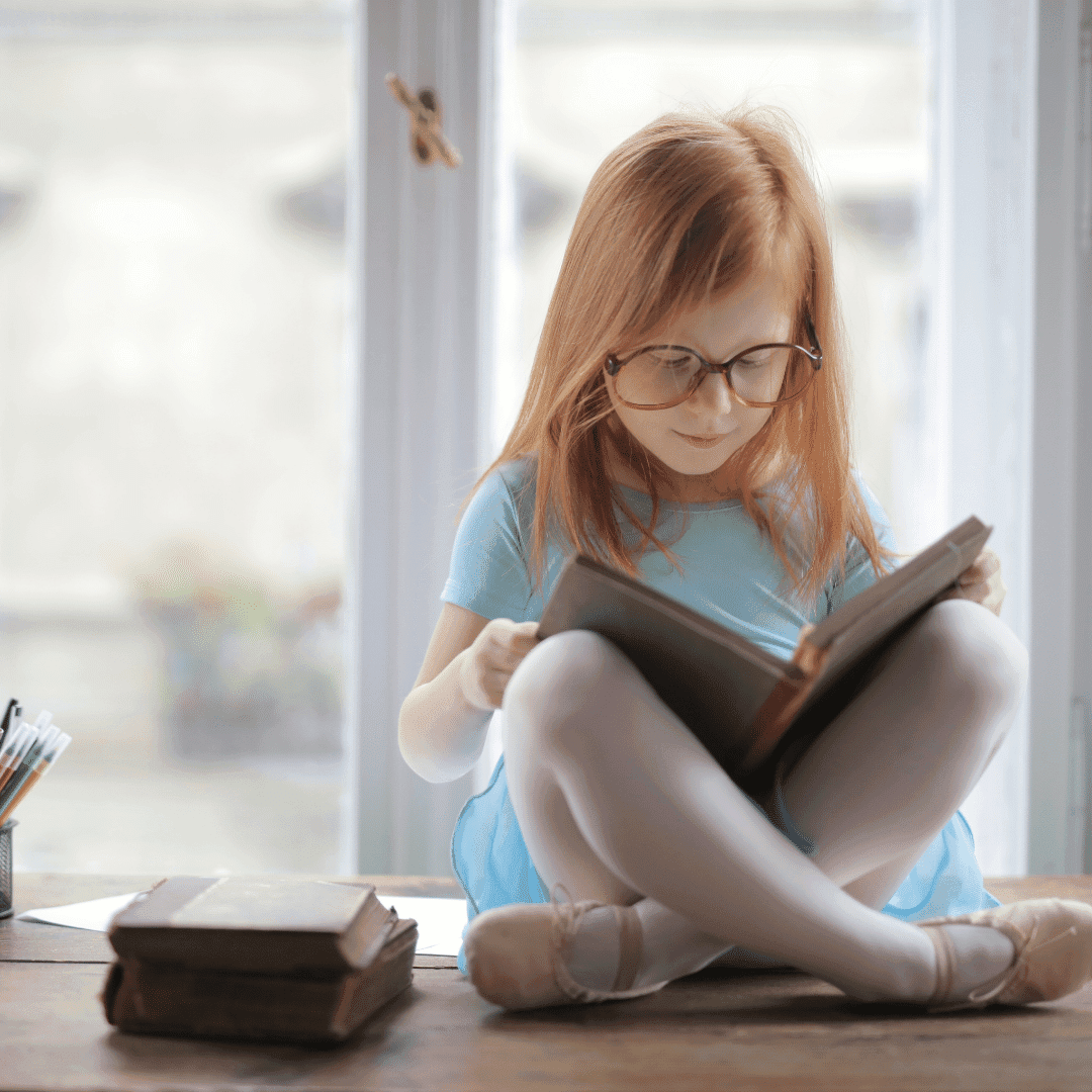 girl reading a book in a windowsill