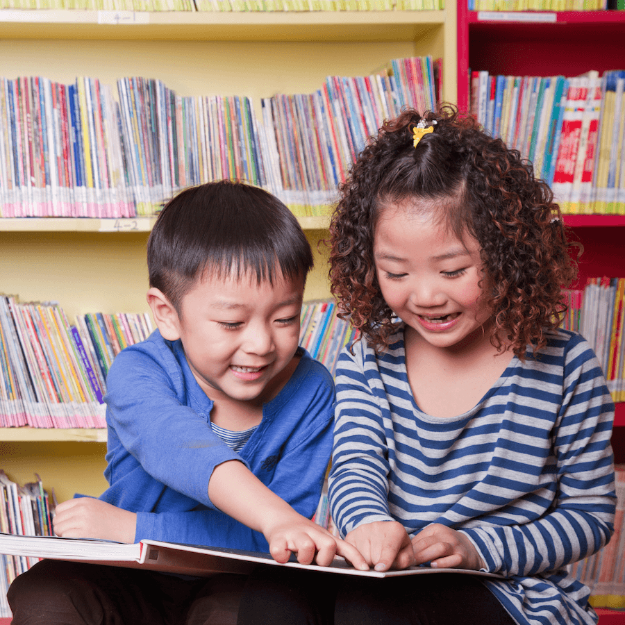 two children looking at a book together