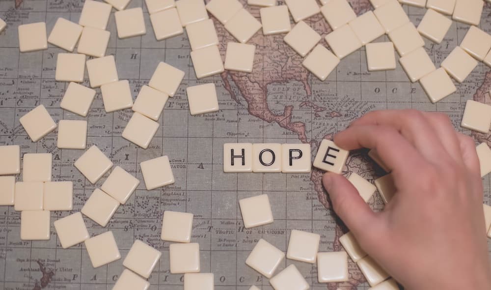 hand spelling HOPE from tiles