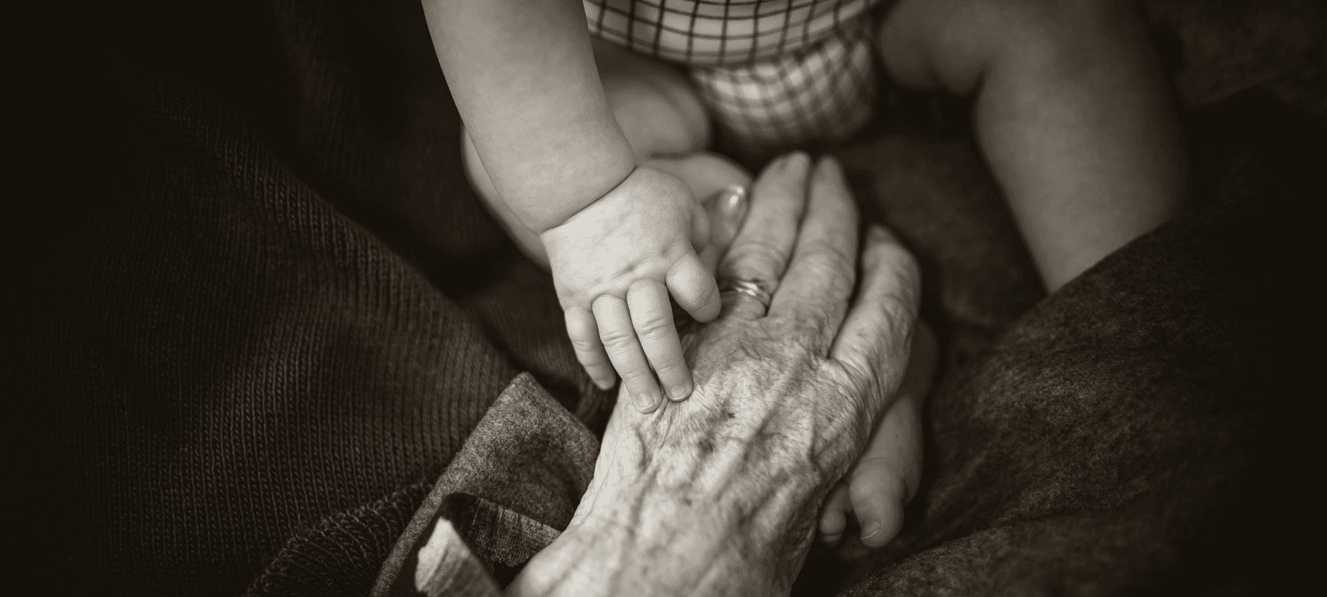 baby's hand embracing grandparent's hand