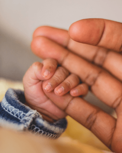 Baby's hand embracing a parent's finger