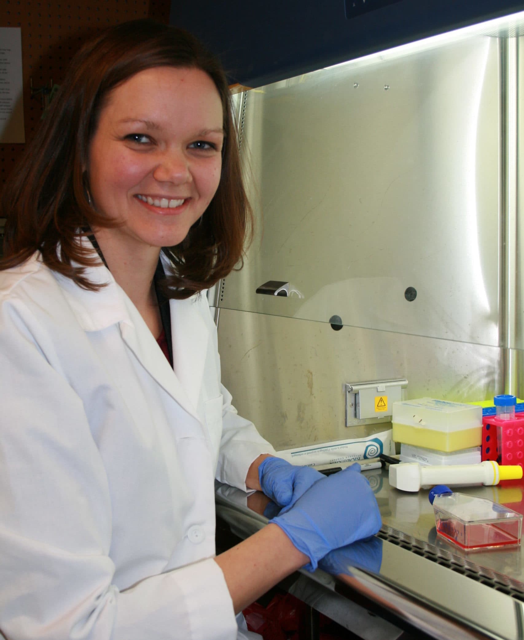Dr. Gubbels sitting next to a chemical hood doing research