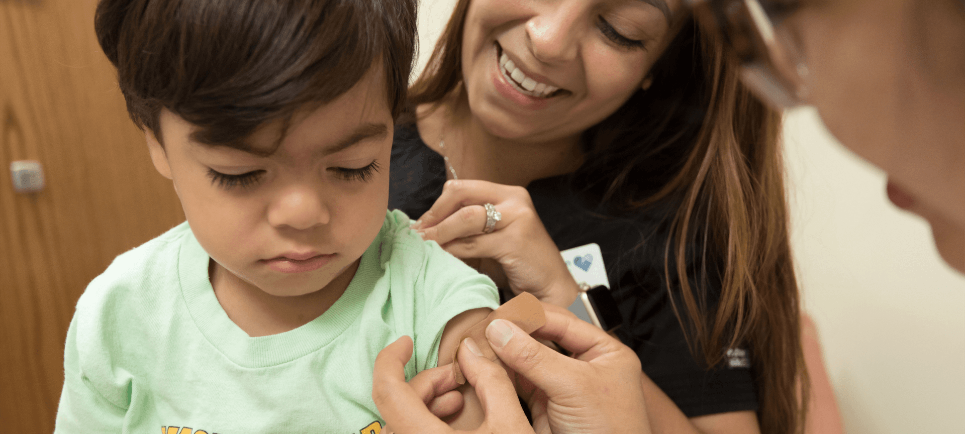 Child getting a bandaid after receiving a vaccine
