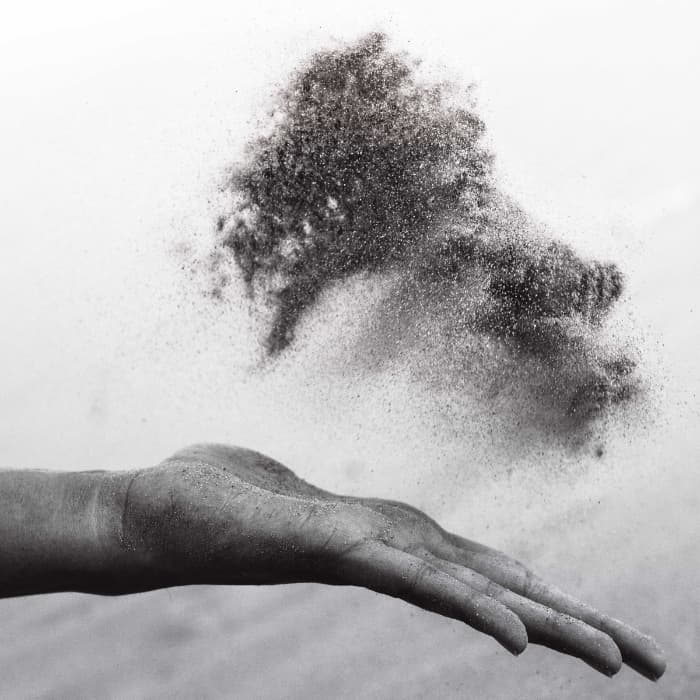 Hand tossing sand into the air
