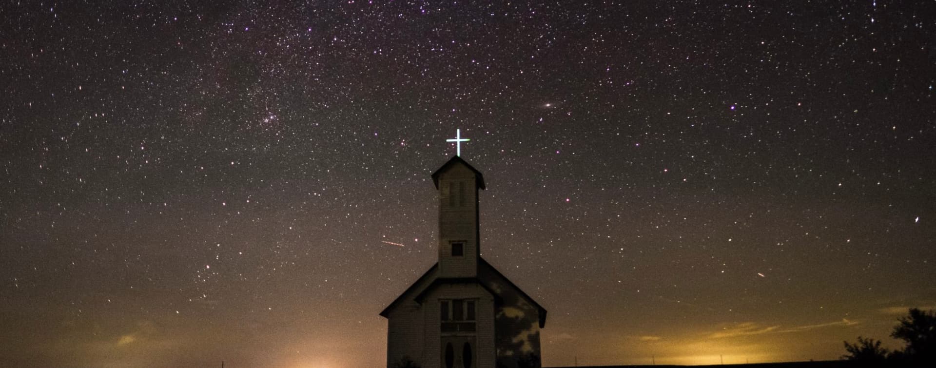 Church surrounded by night sky full of stars