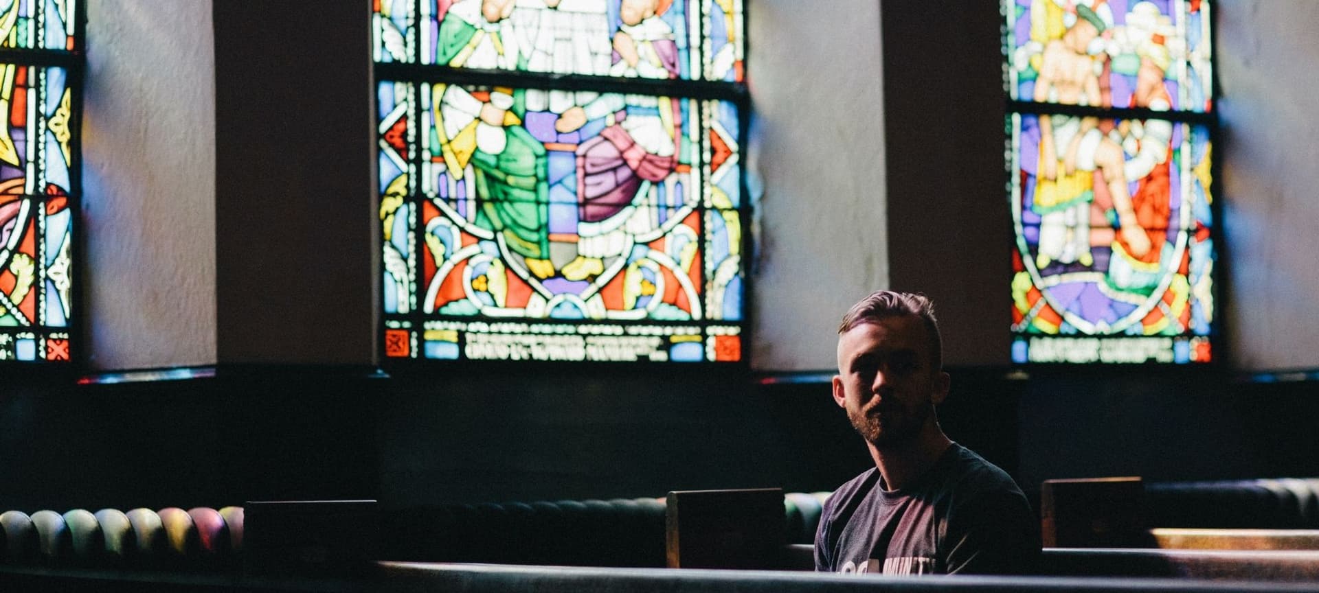 Man sitting on pew in empty church
