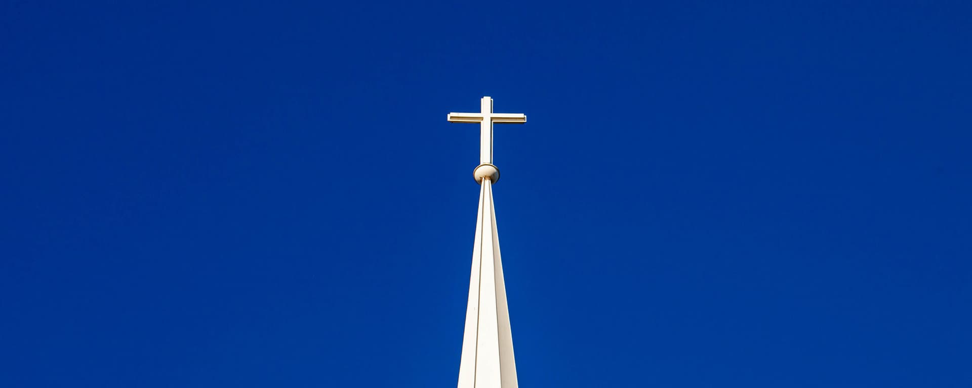 White cross on top of church steeple