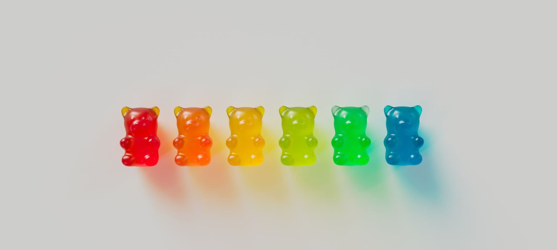 Different colors of gummy bears lined up in a row