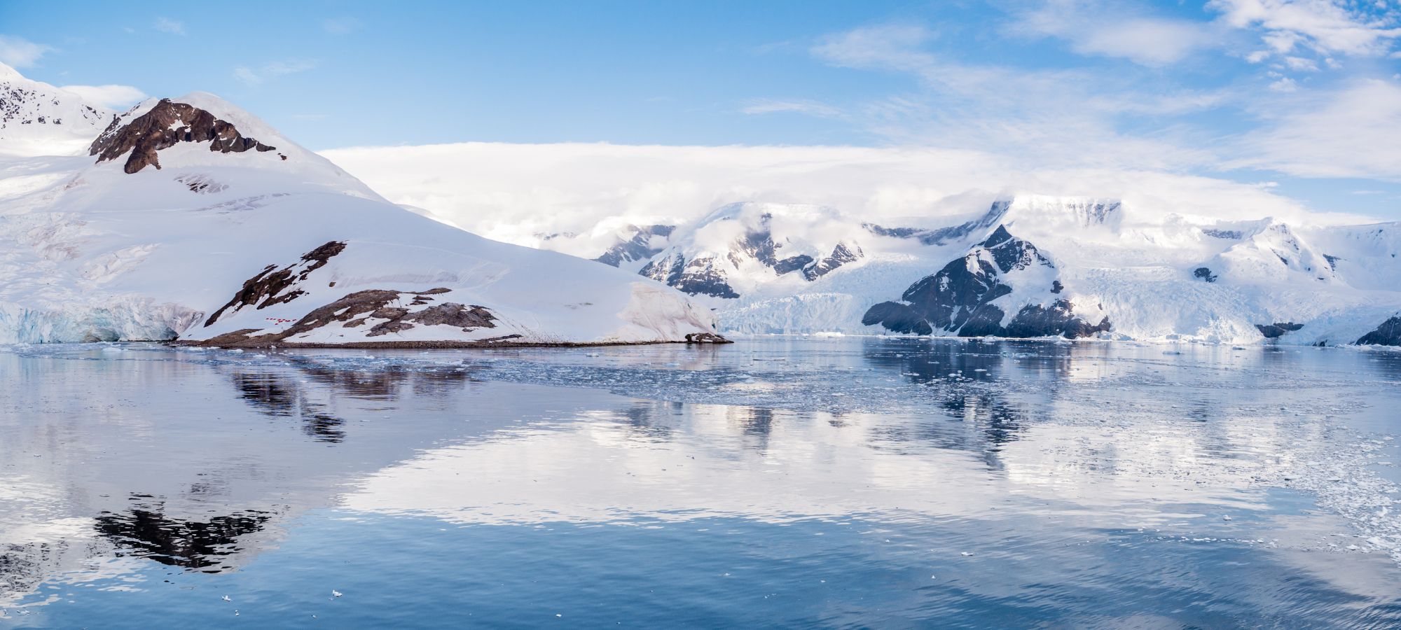 Picture from Antarctica of snowy mountains and reflective water
