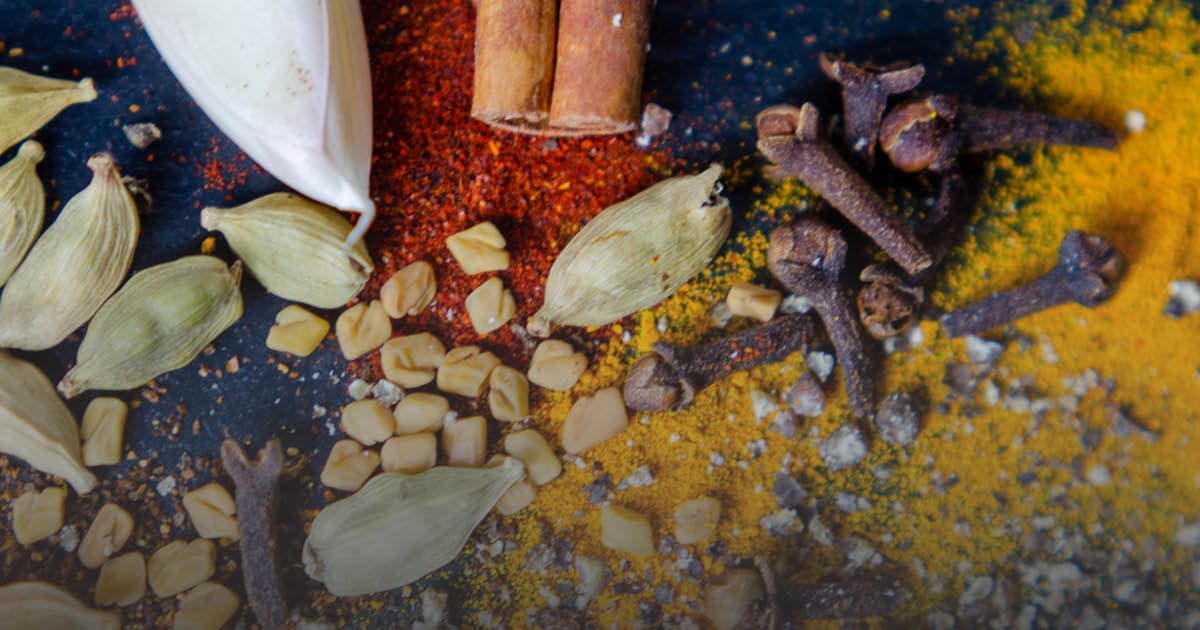 A variety of spices spread on black background