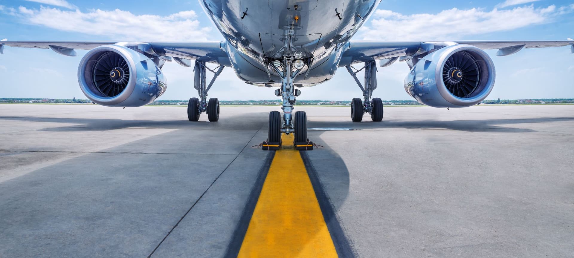 A closeup of an airplane's jet engines, as the airplane is grounded on runway.