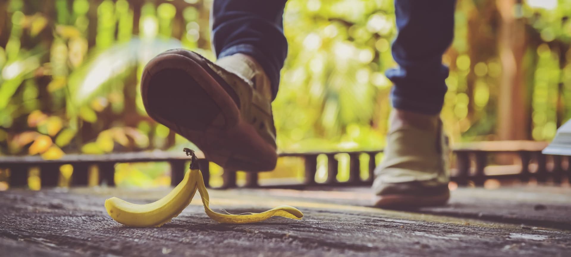 A closeup of a person's foot about to step on a banana peel.