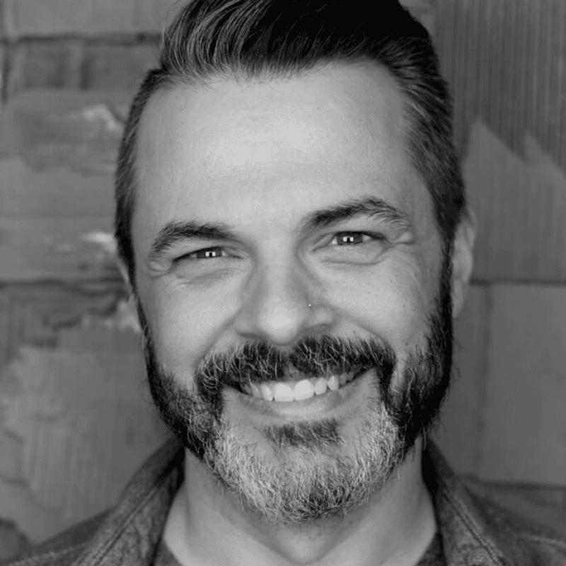 A photo of Jesse Eubanks. Jesse is a man with a black and grey beard and hair swooped backwards.