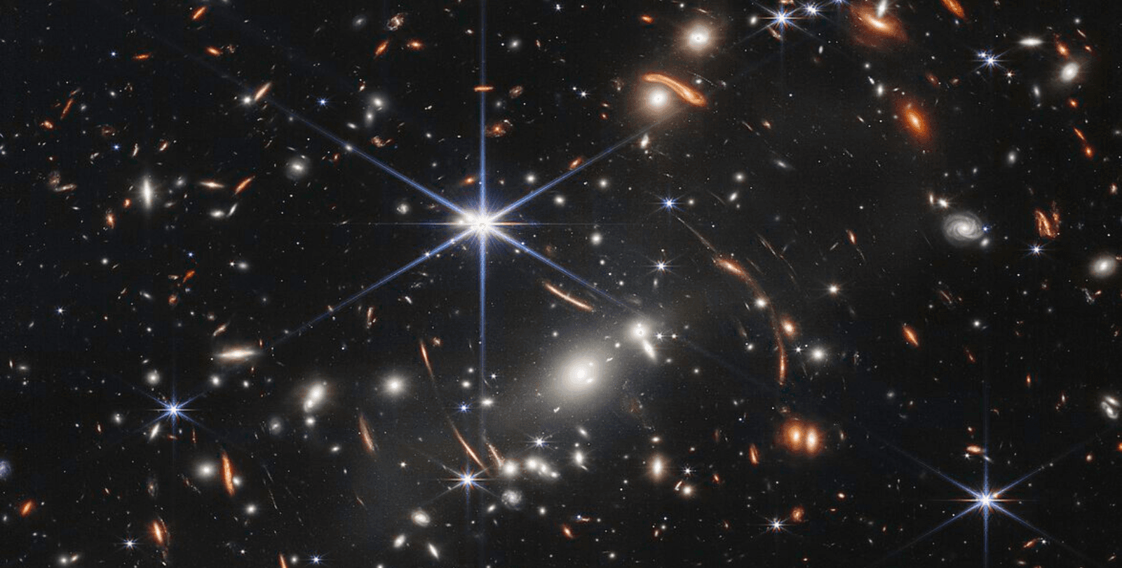 A portion of the first deep field image taken by the James Webb Space Telescope. Hundreds of galaxies shine against the blackness of space.