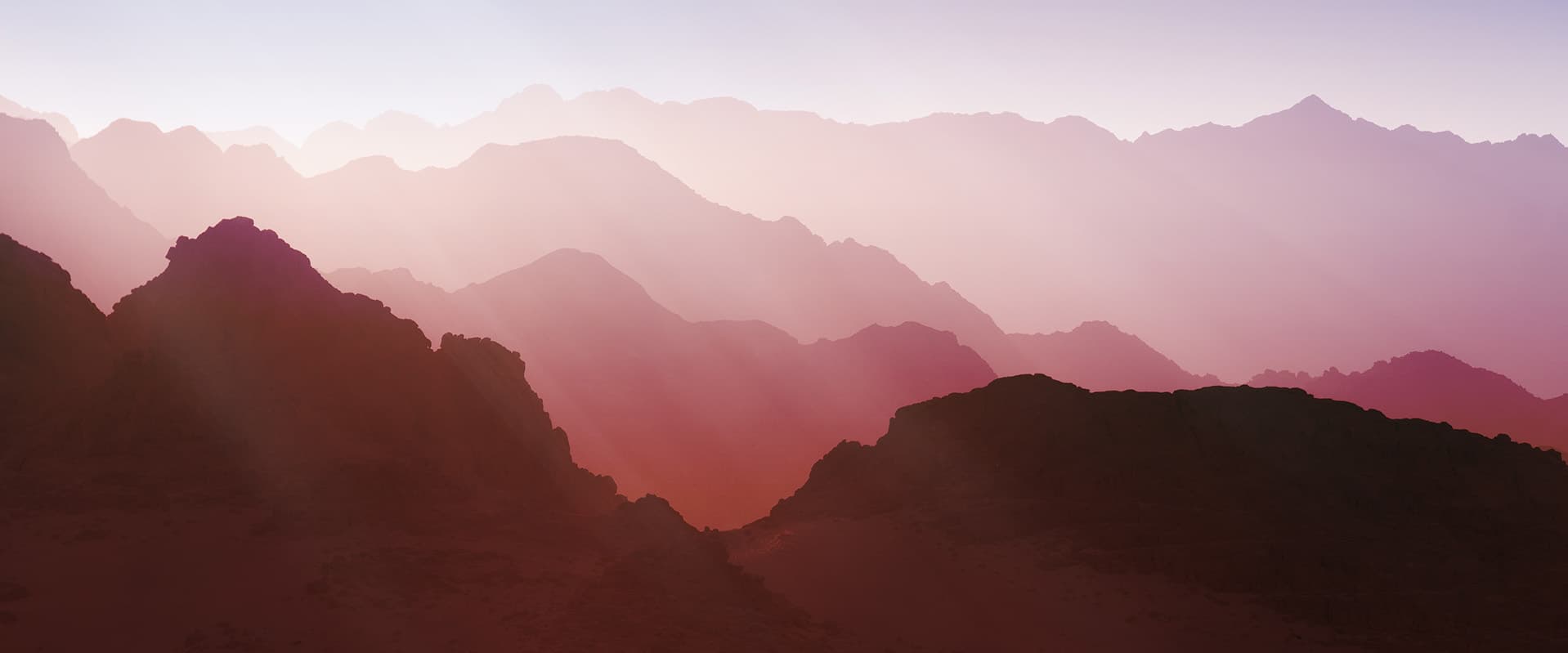 mountains with pink sky and rays of light