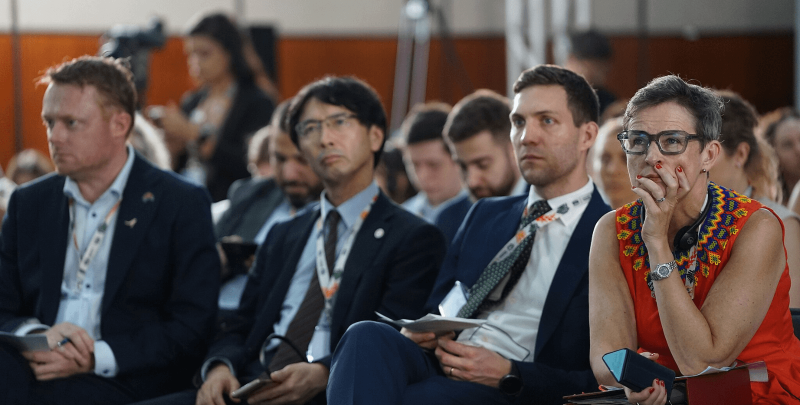 A group of COP30 attendees sit and watch an event.