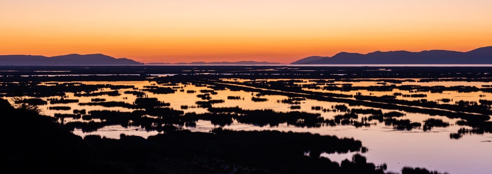 Sunrise over the horizon at Lake Titicaca, Peru