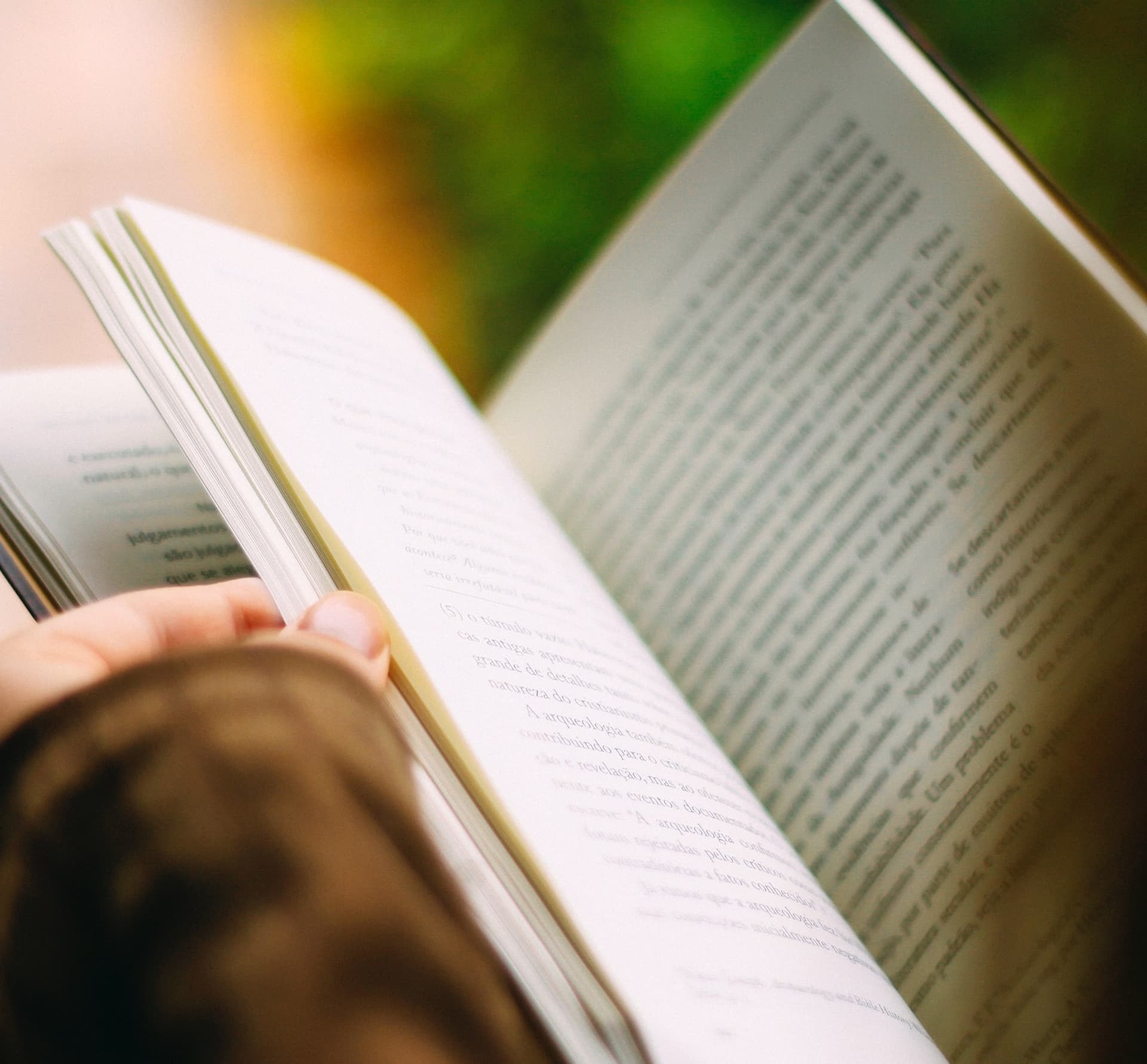 a hand is holding a book page open
