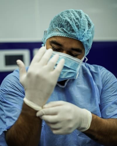 Medical doctor putting on gloves