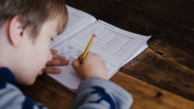 Boy doing school work at table